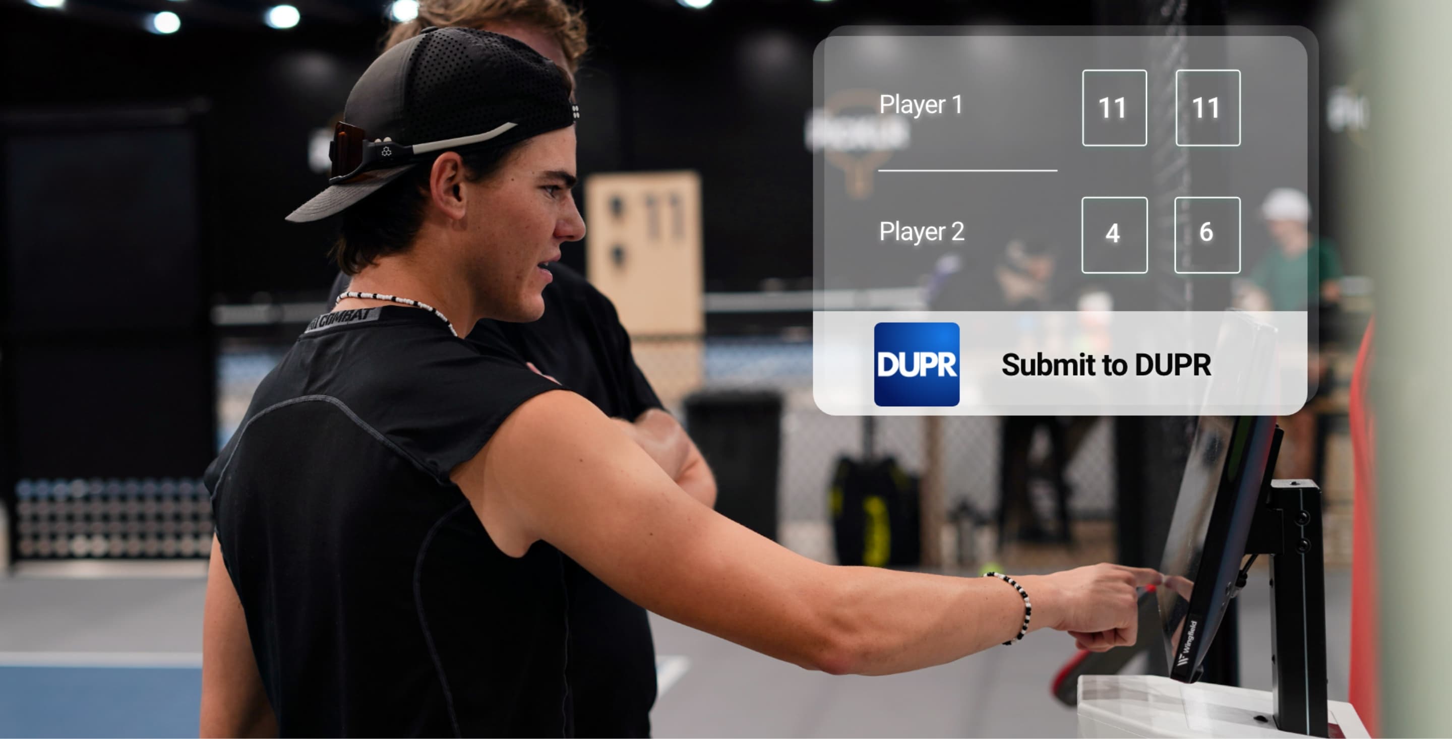 Spieler trägt DUPR-Match-Ergebnis per Touchscreen am Wingfield-System ein