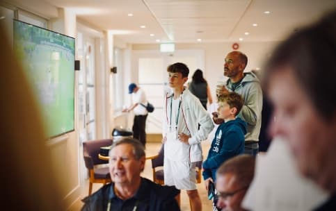 Tennis player watching tennis match.