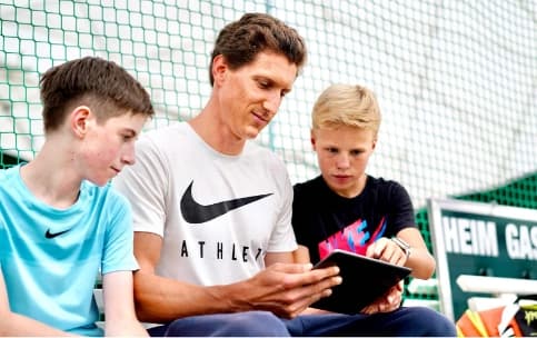 Trainer on a bench with smartphone.